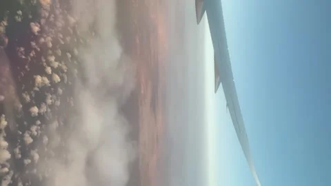 Vertical view from inside an airplane with clouds and blue sky Stock Footage 251708660