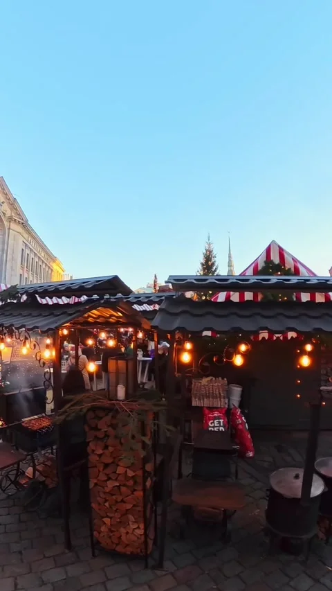 Vertical view inside Riga Old Town Christmas market with striped stalls, warm Stock Footage 328613137
