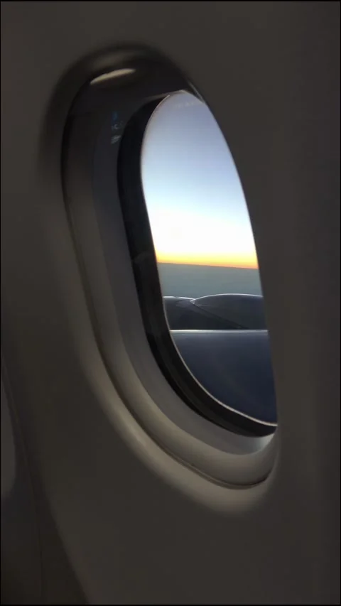 Vertical view: a jet engine and sunset through the cabin window. Stock Footage 332618455