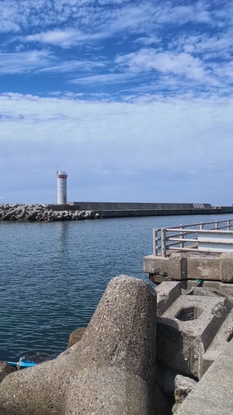 Vertical View of Kurobe Harbor and White Lighthouse Stock Footage 346186737