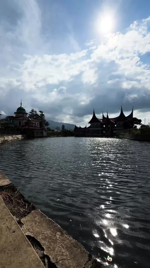 Vertical View Lake Water and Silhouette of Traditional Minangkabau Rumah Gadang Stock Footage 345953974