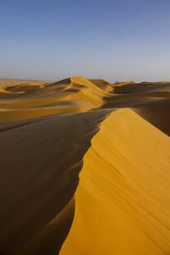Vertical view of a large sand dune ridge with rippled patterns leading towa.. 库存照片