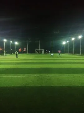 A vertical view of a local artificial turf soccer field illuminated by bright Stock Photos