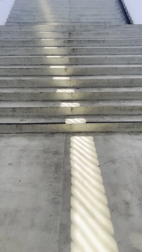 Vertical View of Long Staircase with Golden Diagonal Light Pattern Vídeos de archivo 342855833