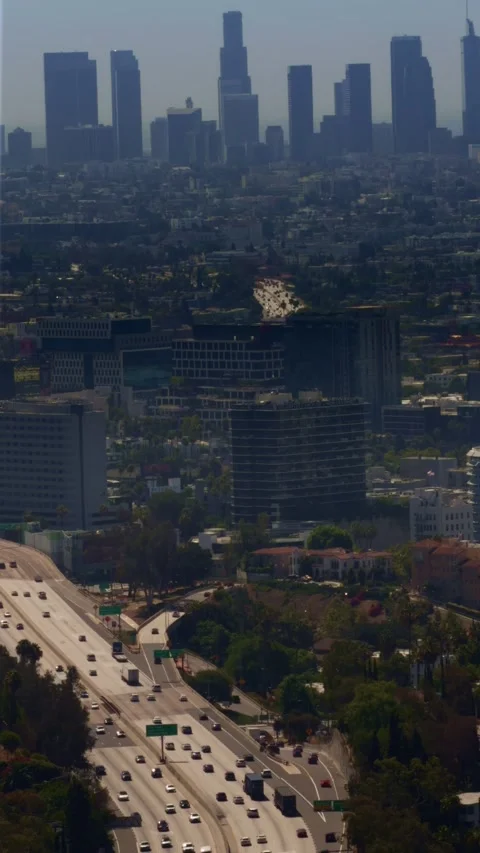 Vertical view of Los Angeles freeway traffic below the downtown skyline Stock Footage 339762367