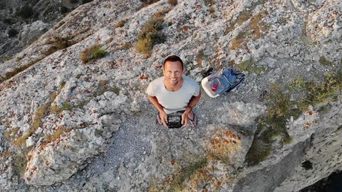 Vertical view man stands on hill top with drone control Video stock 103180823
