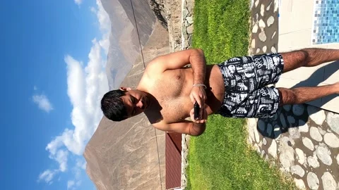 Vertical view of a man with swimming clothes in the swimming pool checking his c Stock-Footage 199553522