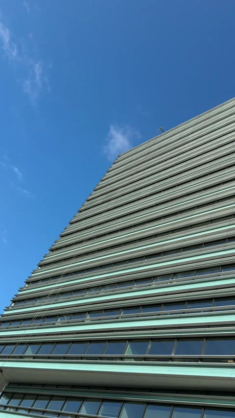 Vertical View of Modern High Rise Facade Against Blue Sky Stock Footage 340512521