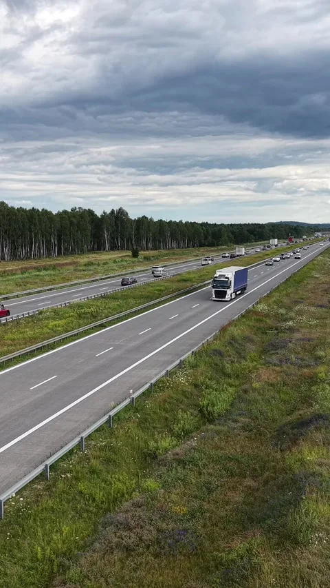 Vertical view. Modern Highway Surrounded by Forest and Fields Video stock 348630866