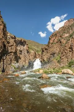 Vertical view of a mountain waterfall and rocky gorge in the Song Kul regio.. Stock Photos