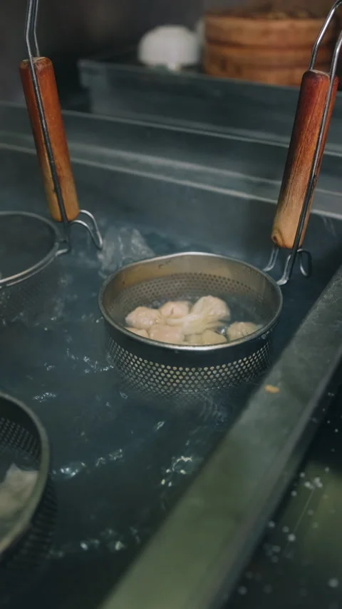 Vertical view of multiple strainer baskets with dumplings in boiling water 動画素材 333894669