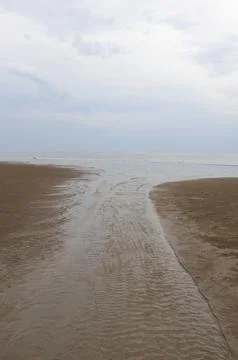 Vertical view of natural water stream flowing on sandy beach Foto stock