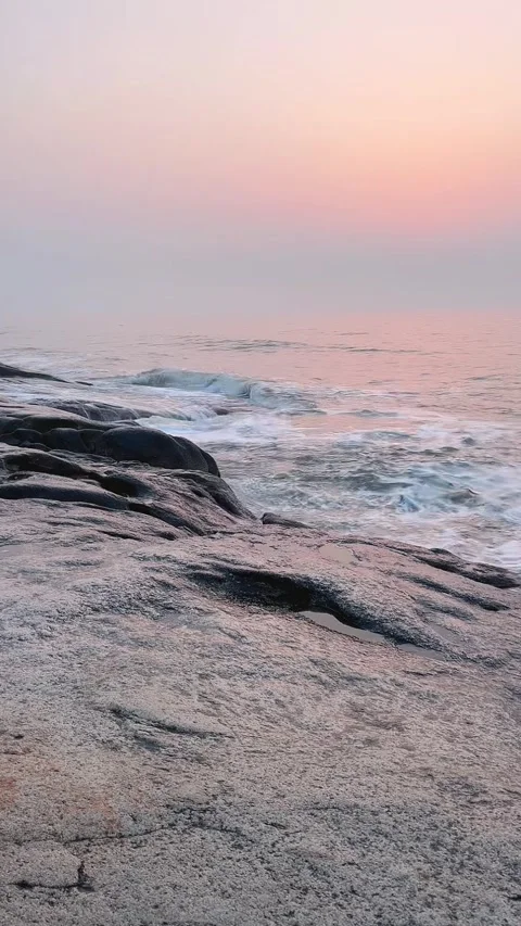 Vertical View of Ocean Waves Crashing on Rocks at Sunset Stock Footage 330144119