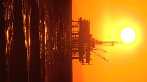 Vertical view of oil platforms at sunset Stock Footage