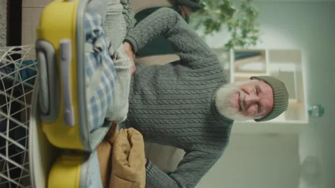 Vertical View.An Old Man is Happy Around a Suitcase with Collected Things. Stock Footage 250299701