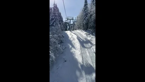 Vertical view over snowy mountain winter forest with chair lift Stock Footage 332113662