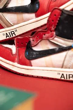 Vertical view of a pair of red Nike Air Jordan 1 Off White over the red backgrou Fotos Stock