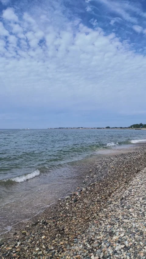 Vertical View of Pebble Beach and Clouds over Sea Stock Footage 346557911
