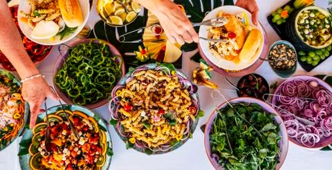 Vertical view of people firends hands taking food from catering table during  Foto stock