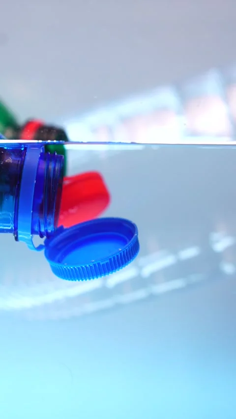 Vertical View, Plastic Bottles With Attached Caps in Clear Water, Stock Footage 289764466