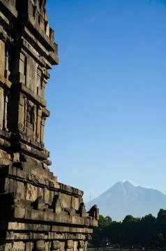 Vertical view of Prambanan Temple stonework reveals hazy Mount Merapi risin.. Foto stock