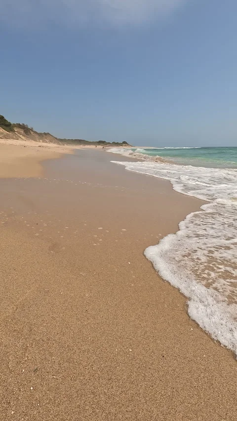Vertical view of a pristine sandy beach with turquoise waves Stock Footage 332074221