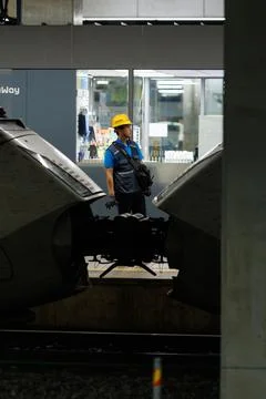 Vertical View of Railway Worker Between High Speed Trains at Station Platform Stock Photos