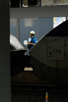 Vertical View of Railway Worker Between High Speed Trains at Station Platform Stock Photos