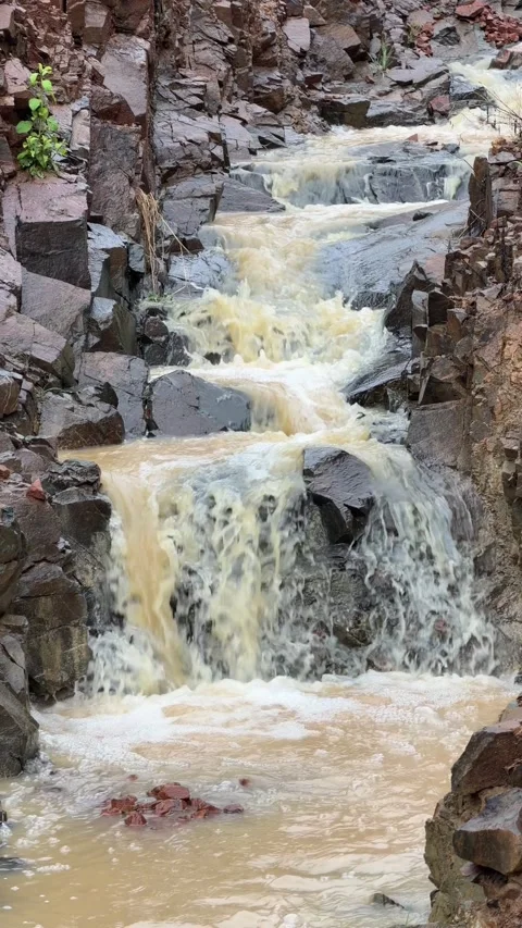 Vertical view of a rain fed stream cascading over rocks in a mountain channel 動画素材 330948342