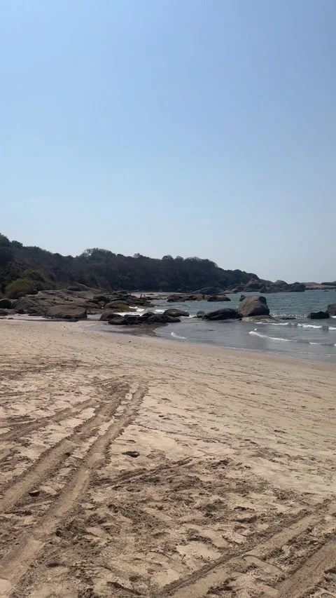 Vertical view of rocky shoreline and ocean waves at Agonda Beach in Goa Видео 342968377