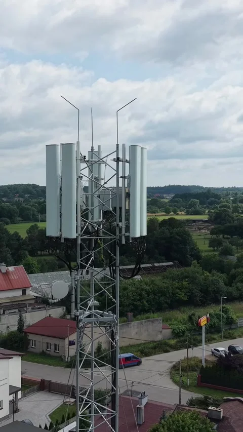 Vertical view. Rural communications tower amidst the trees and fields Stock Footage 348630932