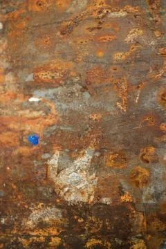 Vertical view of Rusty weathered metal wall with bits of Paper and debris han Stock Photos
