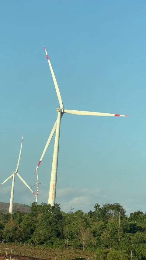 Vertical view of several wind turbines standing across a hillside landscape reco Stock Footage 338001656