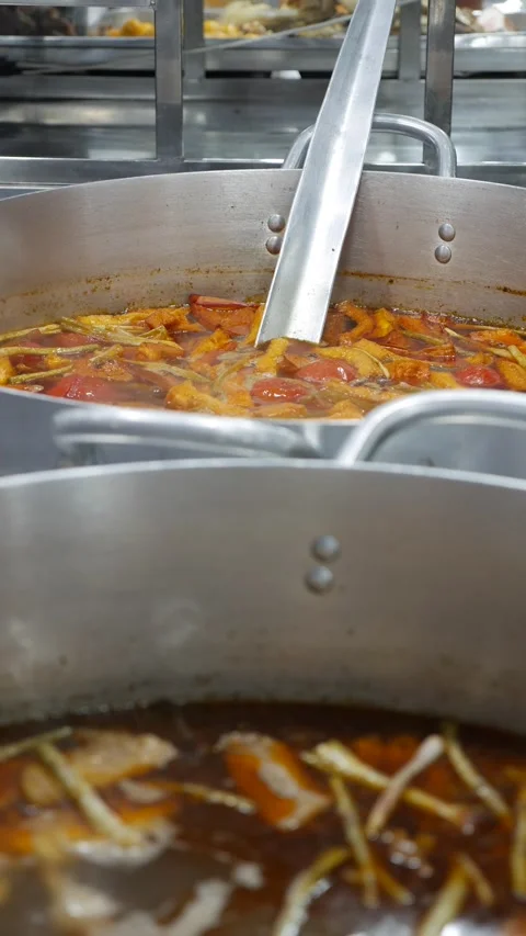 Vertical view shows Bun Mang Vit soup boiling inside large metal pot during Vidéo 333197818