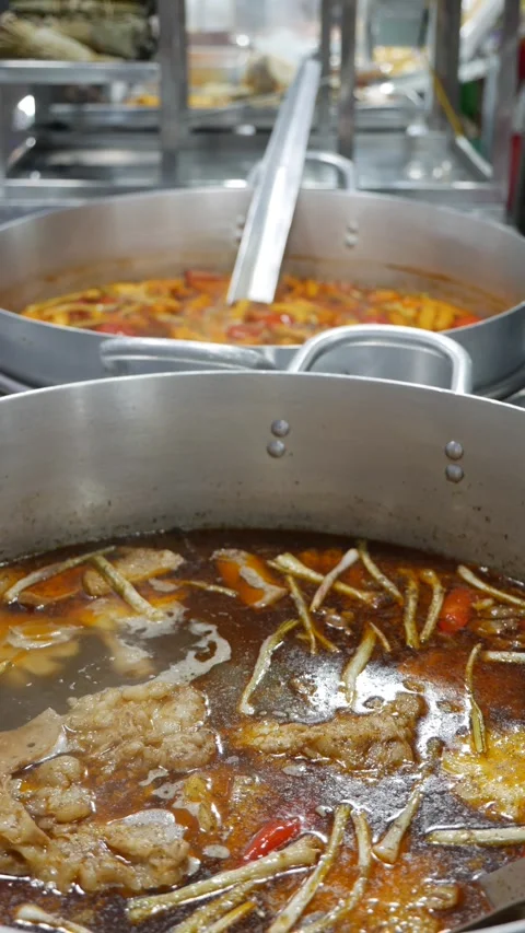 Vertical view shows Bun Mang Vit soup boiling in a large metal pot at a busy mar Stock Footage 338001119
