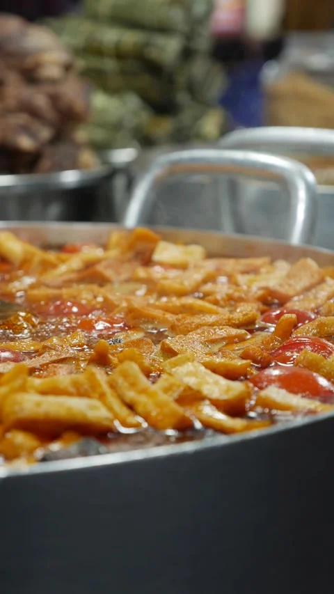 Vertical view shows Bun Rieu soup boiling in a metal pot during preparation at a Видео 334417445