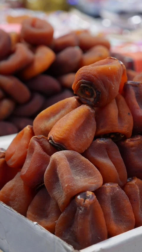 Vertical view shows dried persimmons arranged in multiple rows on a retail Stock Footage 335206342