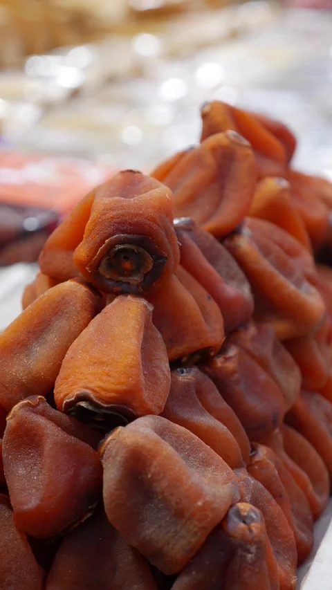 Vertical view shows dried persimmons arranged in dense pyramid stack on a sellin Stock Footage 338001253