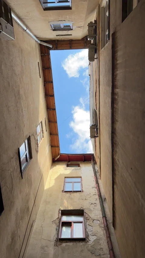 Vertical view of the sky with floating clouds between the narrow walls of the Video stock 273373016