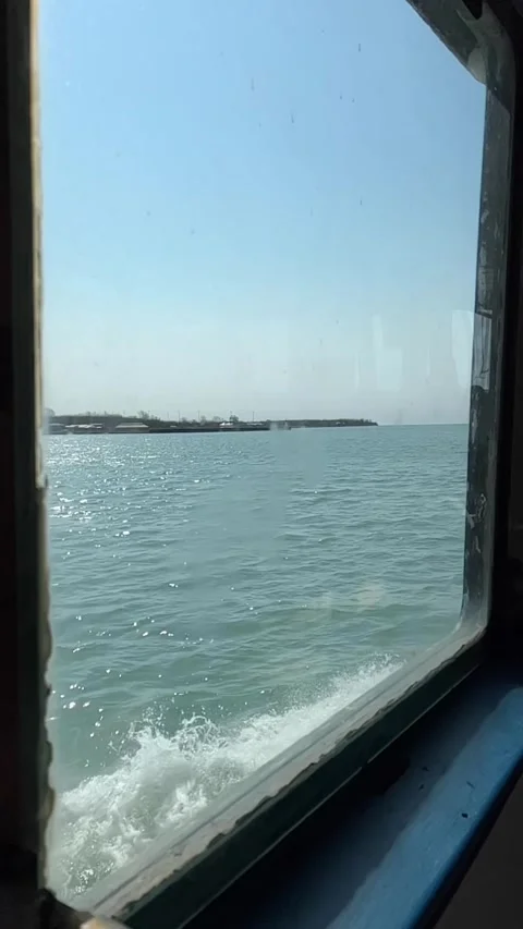 Vertical view of slow motion view from the window of a ship in a sunny day Stock Footage 238490051