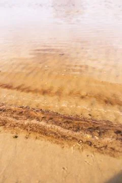 Vertical view of small sandy patterns in the shallow waters of the ocean Stock Photos