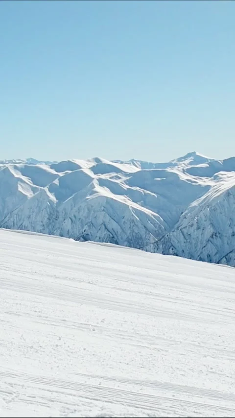 Vertical view snow covered Caucasus mountain range with groomed ski slope i.. Stock Footage 311873664