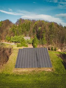 Vertical view of solar panels stacked on a sunny side of the hill in the country Stock Photos