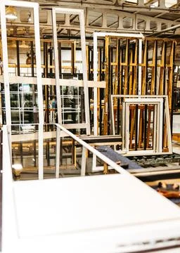 Vertical view of stacked metal window frames in carpentry workshop Stock Photos