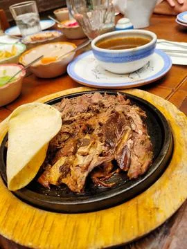 Vertical view of Steaming dish called Birria with soup and Handmade Tortilla Stock Photos