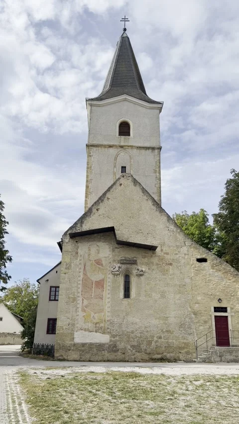 Vertical view of stone church gable and bell tower in St. Egyden am Steinfeld 스톡 동영상 348095413