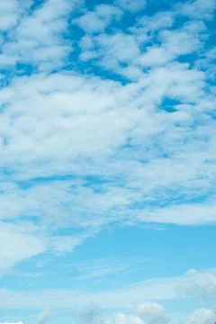 Vertical view of a summer sky filled with white clouds fading into clear blue Stock Photos