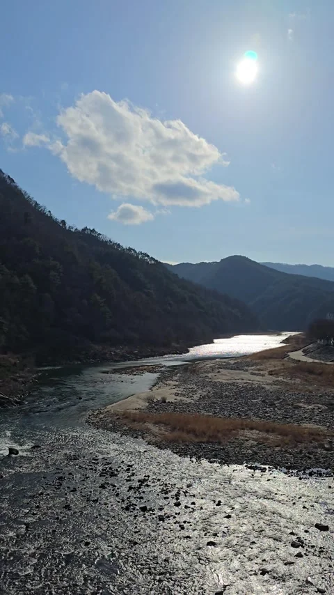 Vertical View of Sun and Clouds Over Glistening River in South Korea Stock Footage 330855341