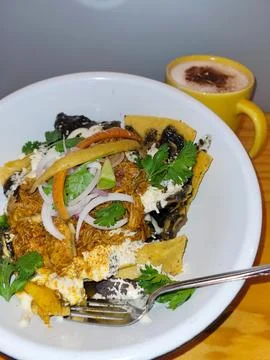 Vertical view of Sunny-Side-Up Egg over Spicy Chilaquiles with Crema Stock Photos