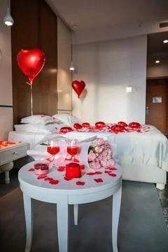 Vertical View of Table with Glasses Desserts and Roses with Decorated Bed Stock Photos